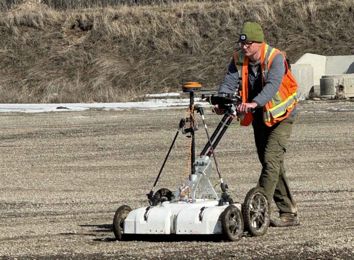 Man pushing a scanner on site or residential school